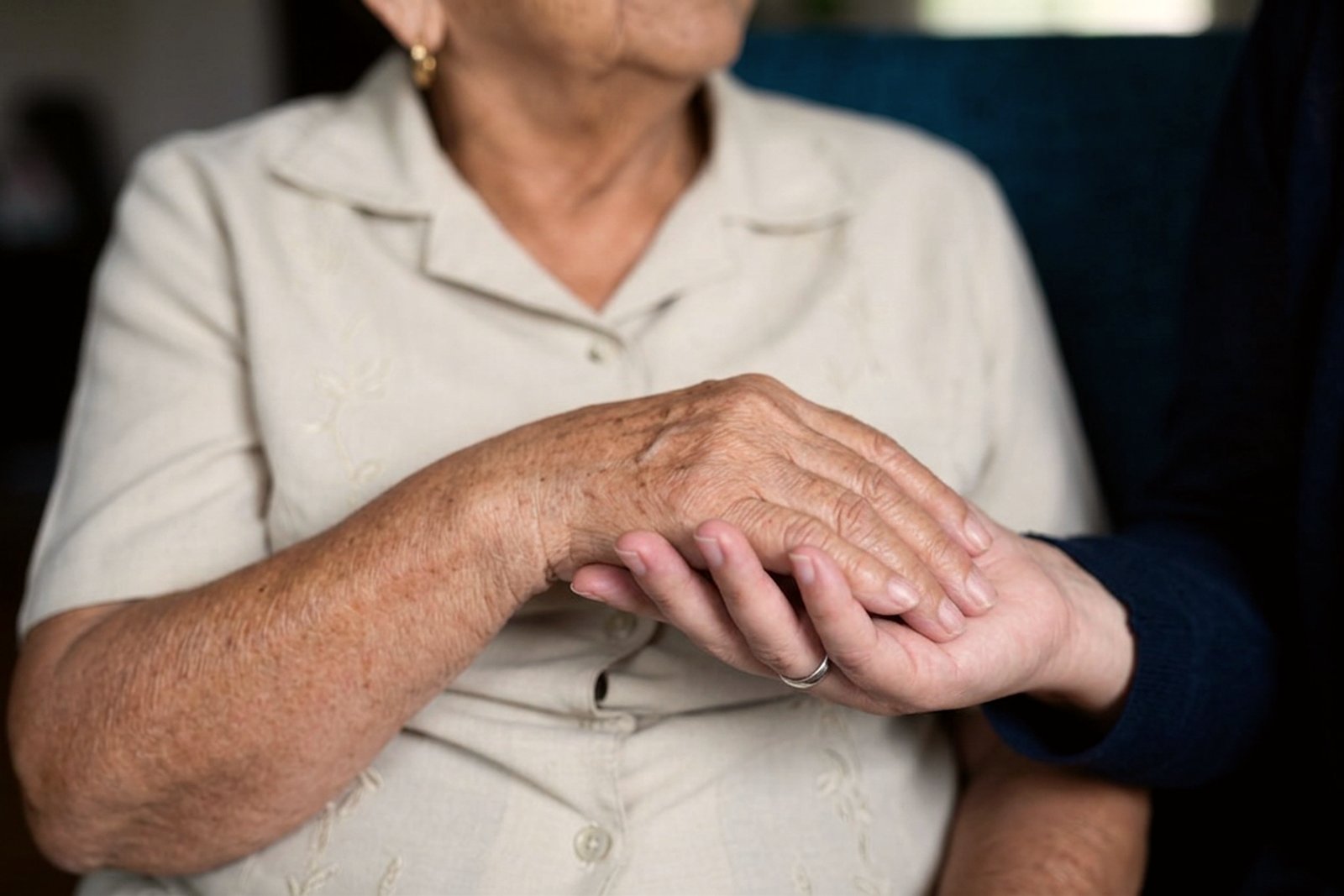A hand resting on an older person's hands