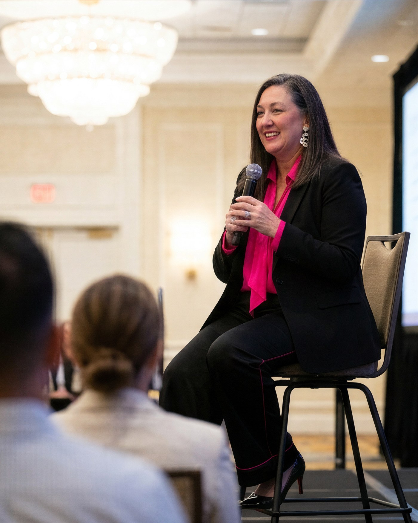 Nikki Patton speaking with a microphone, seated on stage in front of an audience